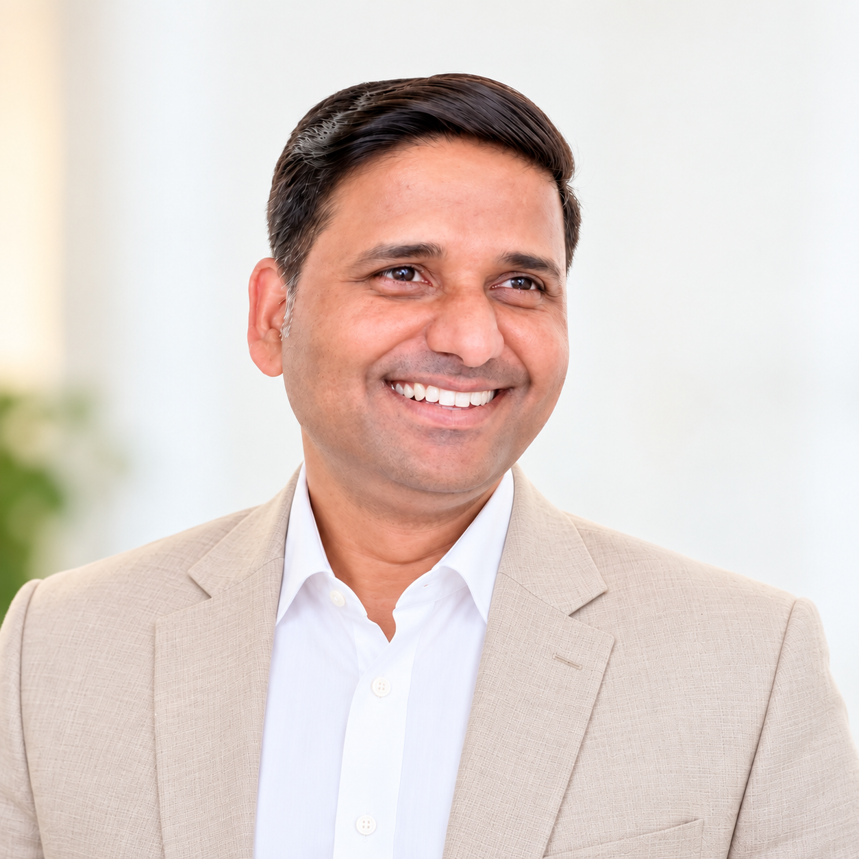 Datta Rokade smiling in a beige blazer over a white shirt
